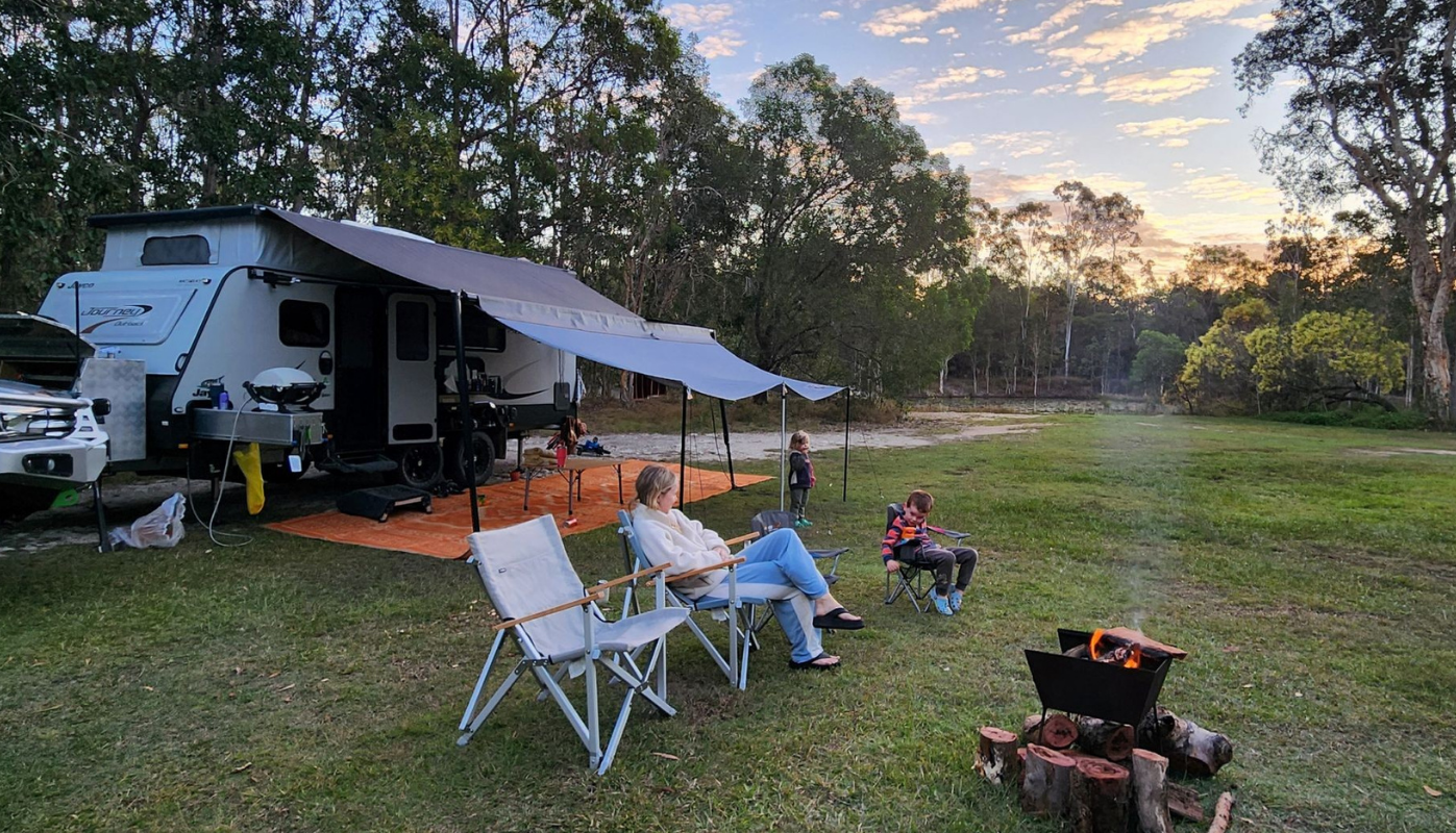 Traveller's Rest 1770 Eco Camping family camped by fire with caravan and awning