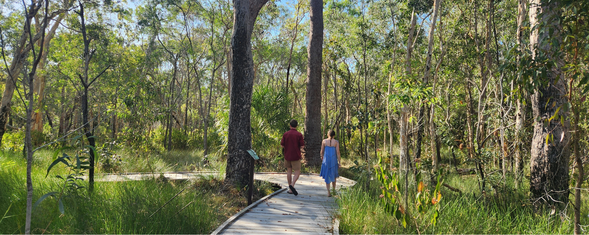 Traveller's Rest 1770 Eco Camping couple walking on board walk through bush land