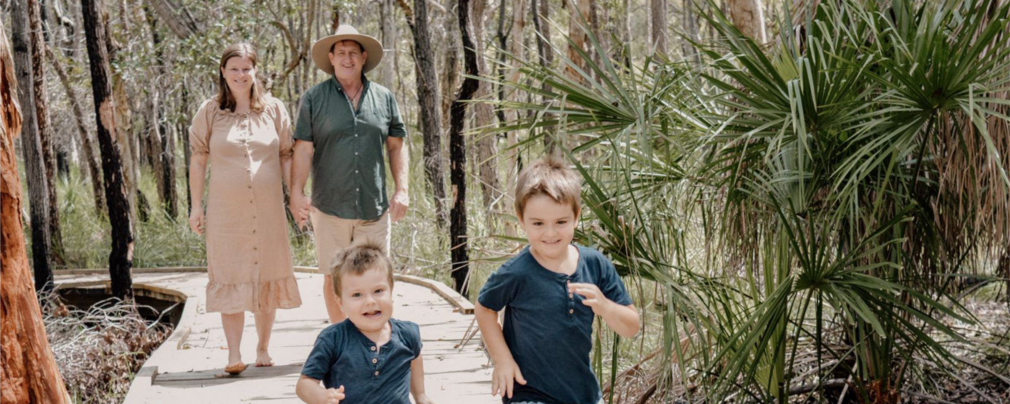 Traveller's Rest 1770 Eco Camping park owners and children running through the bush on the board walk