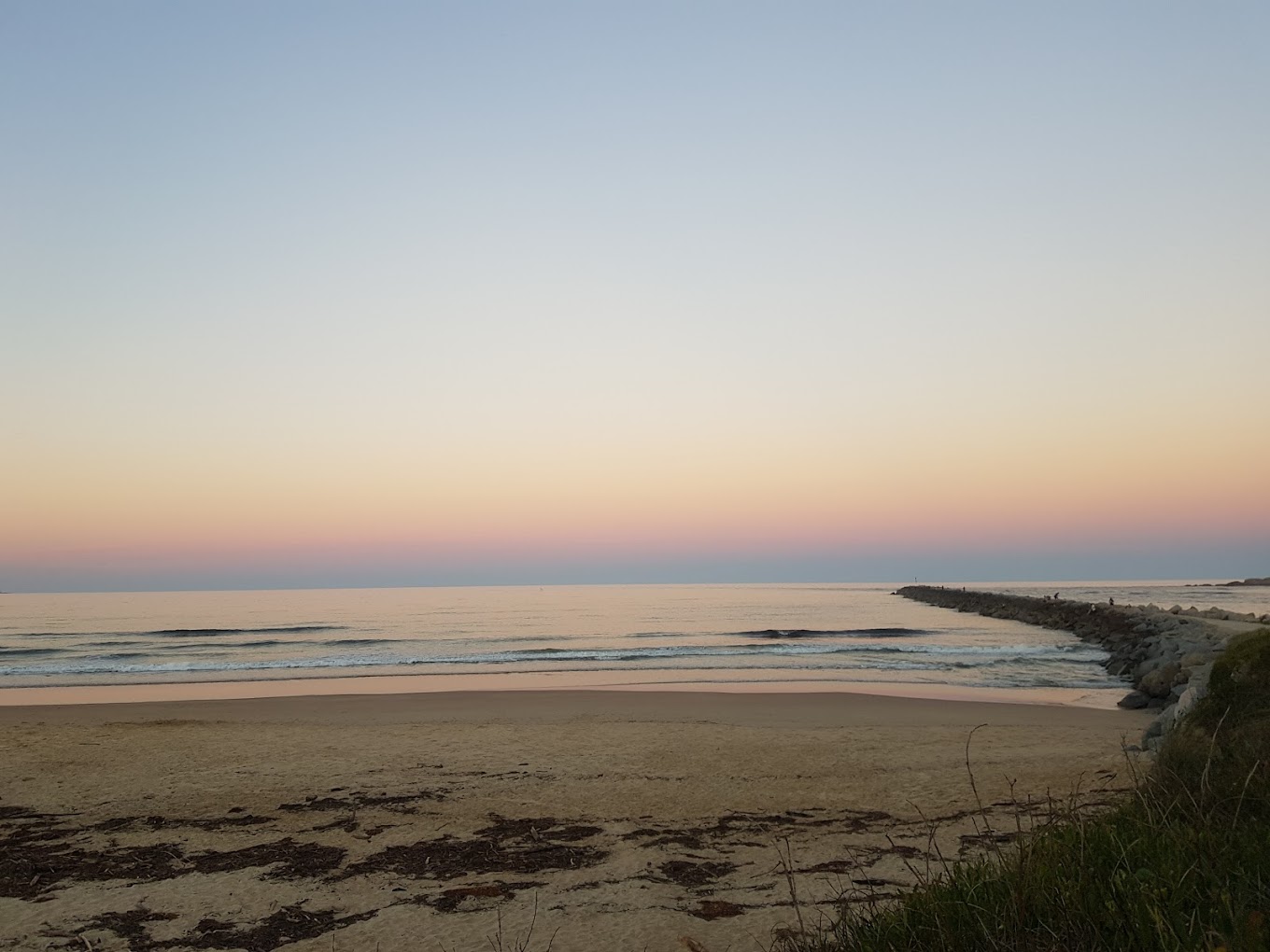 Moruya North Head Campground beach with jetty with soft pink sky