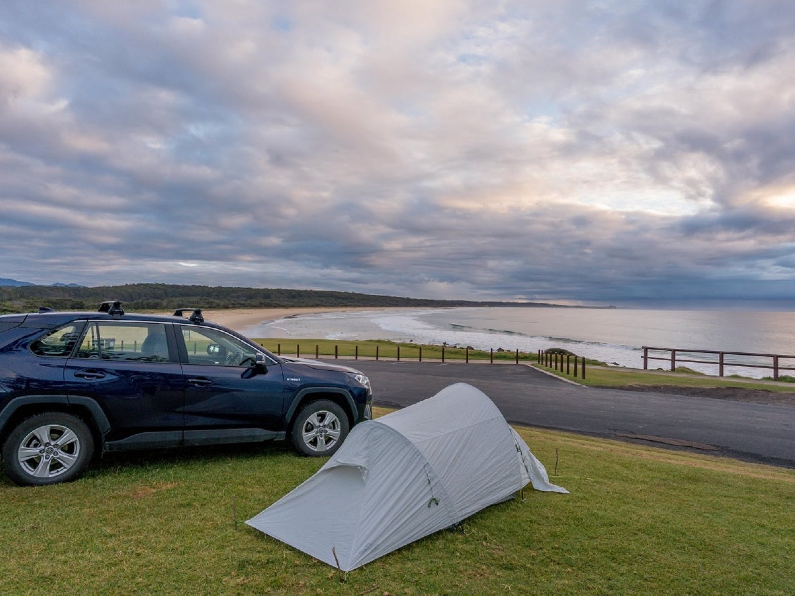 dalmeny campground car and swag atop coastal view of beach and sea in soft morning light