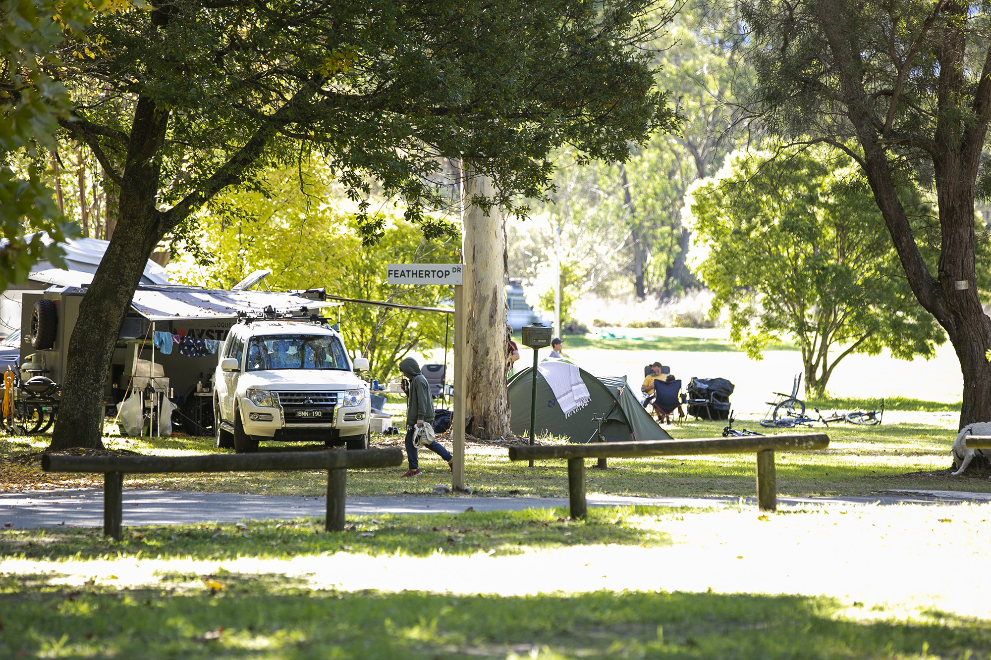 tawonga tourist park caravan and tents in distance on grassed area with river in background