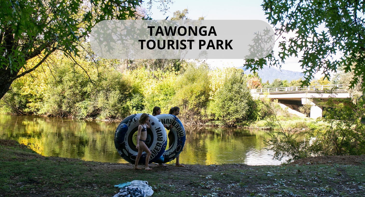 tawonga tourist park scenic shot of river with kids carrying inflatable tires ready to go swimming